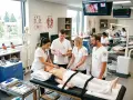 Studenci szkoły dla dorosłych ćwiczą opiekę medyczną na fantomie.