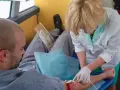 Pielęgniarka wykonuje badanie przedmiotowe, pobierając krew od pacjenta.
