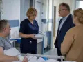 Pielęgniarka omawia z pacjentem i jego bliskimi dokumenty, co może dotyczyć odpowiedzialności cywilnej pielęgniarki.