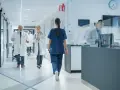 Lekarze i pielęgniarki w szpitalnym korytarzu, przykład efektywnego zarządzania zasobami ludzkimi.
