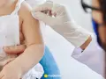 Położna podczas kursu szczepień podaje zastrzyk dziecku.
