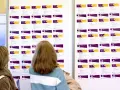 Dwie kobiety przeglądają tablicę z ofertami pracy, szukając rozwiązań problemu bezrobocia w Polsce.