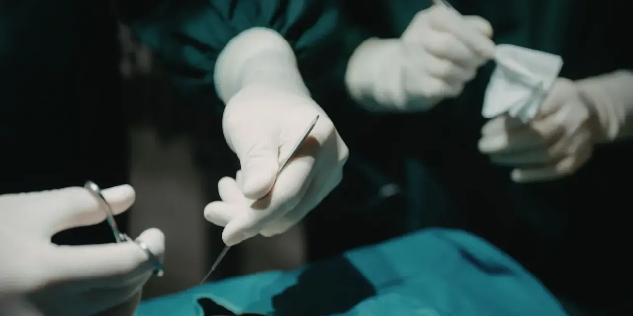 Chirurgiczne rękawiczki i narzędzia, przygotowanie do zabiegu. Znieczulenie miejscowe zapewnia komfort pacjentowi.