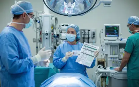 Pielęgniarka omawia przygotowanie pacjenta do zabiegu operacyjnego, prezentując checklistę bezpieczeństwa.