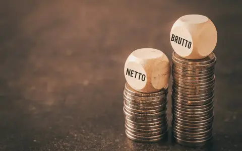 Dwie wieże monet, jedna z napisem "NETTO", druga z "BRUTTO". Symbolizują różnicę między zarobkami, pokazując, jak średnia krajowa netto różni się od brutto.