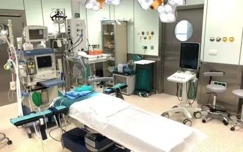 Sala operacyjna gotowa do zabiegu. Pielęgniarka instrumentariuszka przygotowała sprzęt: aparat do znieczulenia, stoły, lampy.