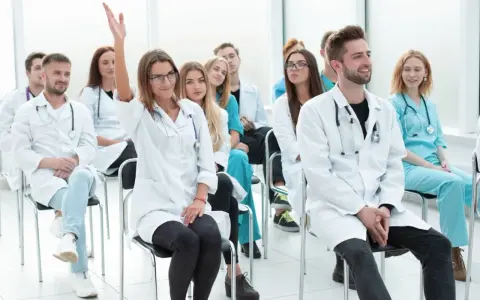 Uczestnicy kursu rejestratorka medyczna, jedna osoba podnosi rękę.