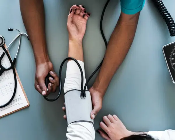 Lekarz mierzy ciśnienie. Podobnie jak w liście motywacyjnym, ważne są kluczowe dane i profesjonalizm.