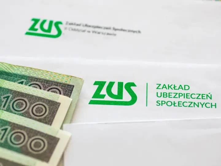 Najnowsze wiadomości o emeryturach czerwcowych: banknoty 100 zł leżą obok dokumentów ZUS.