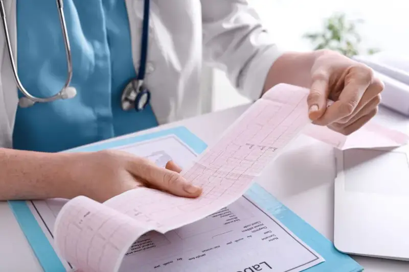 Pielęgniarka analizuje zapis EKG, ucząc się interpretacji podczas kursu EKG dla pielęgniarek online.