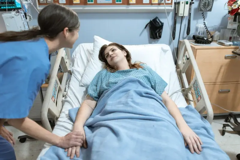 Pielęgniarka trzyma za rękę pacjentkę w szpitalnym łóżku. To jak list motywacyjny dla zdrowia, pełen nadziei.
